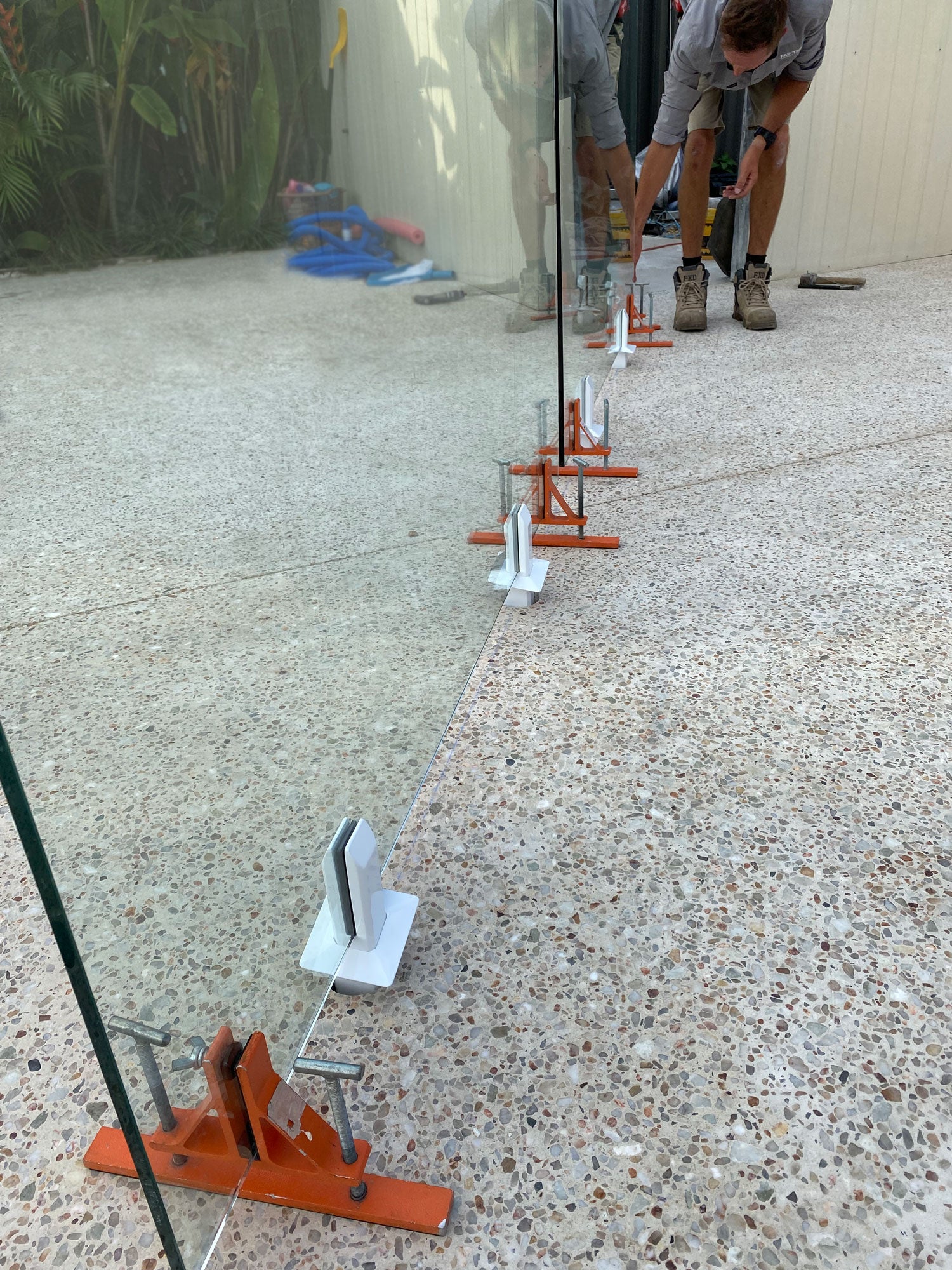 Turn knobs on GlassMate tool to easily adjust each panel of glass to ensure they are level, plumb and perfectly aligned with other panels before setting spigots into concrete